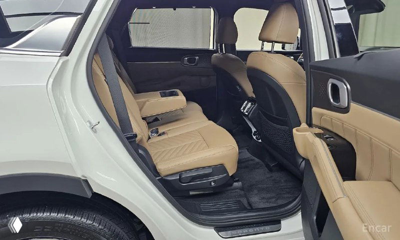 Задний ряд сидений Kia Sorento: три посадочных места, бежевый рельефный салон и пространство для пассажиров второго ряда в раскрытом виде.