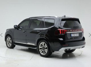 Корма и правый задний угол Kia Mohave: вид на заднюю часть, форму фонарей и встроенные выхлопные патрубки в студийных условиях.