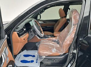 Переднее сиденье водителя Kia Mohave: коричневые кожаные кресла, защитные плёнки и регуляторы положения сиденья — подробный ракурс салона.