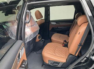 Второй ряд сидений Kia Mohave: коричневые кожаные места, простор для пассажиров и общий вид заднего салона с открытой дверью.