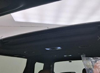 Демонстрация панорамного люка в потолке Kia Mohave: чёрный потолочный контур, освещение и общий вид сверху салона.