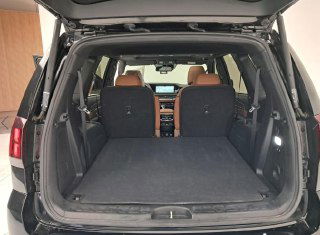 Багажное отделение Kia Mohave с откинутыми задними сиденьями: большой ровный грузовой отсек и вид на салон из багажника.