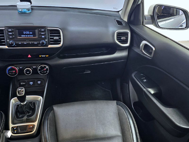 Пассажирская сторона передней части салона Hyundai Venue: вид на бардачок, дверную обшивку и панель консоли в интерьере автомобиля 2019 года.