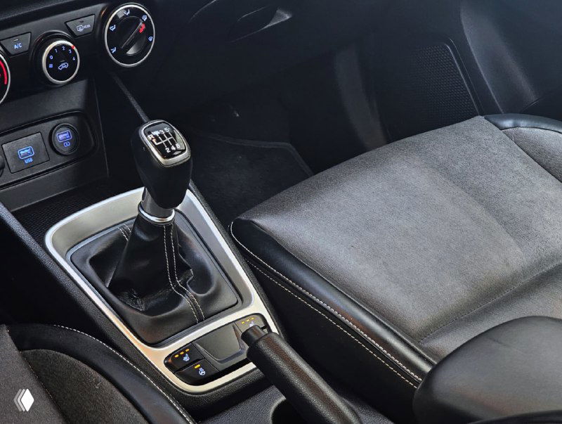 Крупный план рычага механической коробки передач Hyundai Venue, ручного тормоза и текстильной отделки сиденья — подтверждение наличия МКПП в объявлении.