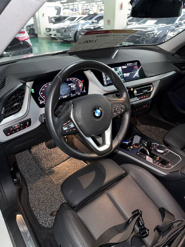 Салон BMW 218D Advantage: панель приборов и мультимедиа, фото сделано с переднего пассажирского места, видно рулевую колонку
