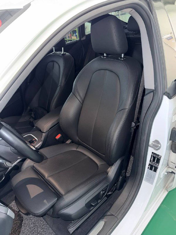 Переднее кожаное сиденье BMW 218D Advantage 2020, вид сбоку с открытой дверью, состояние обивки и регулировки видны подробно