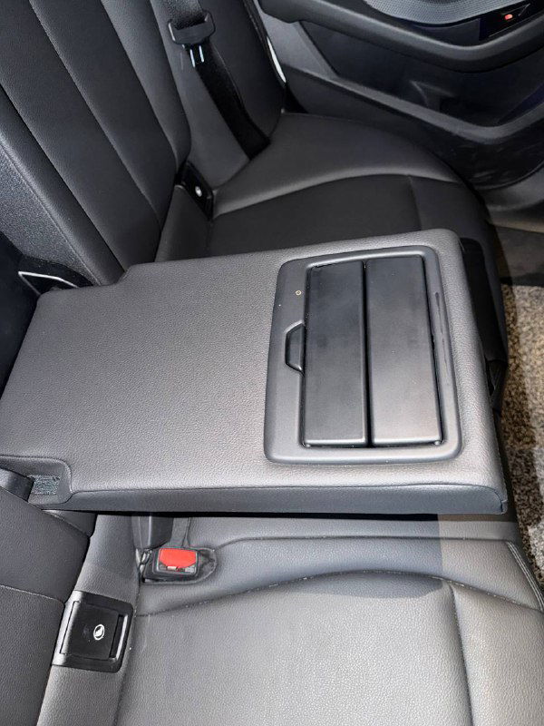 Подлокотник и деталь центральной консоли BMW 218D Advantage, вид крупным планом на элементы хранения и отделку салона