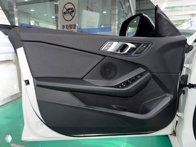 Внутренняя панель двери BMW 218D Advantage с динамиком и декоративными элементами, вид при открытой двери в салоне