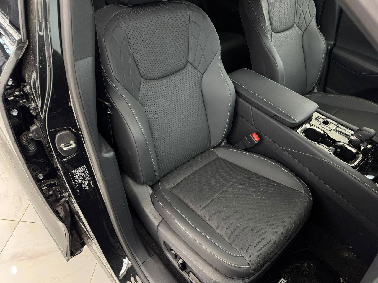 Крупный план переднего пассажирского сиденья и центрального тоннеля Lexus RX300 2025 — обивка и швы видны детально.