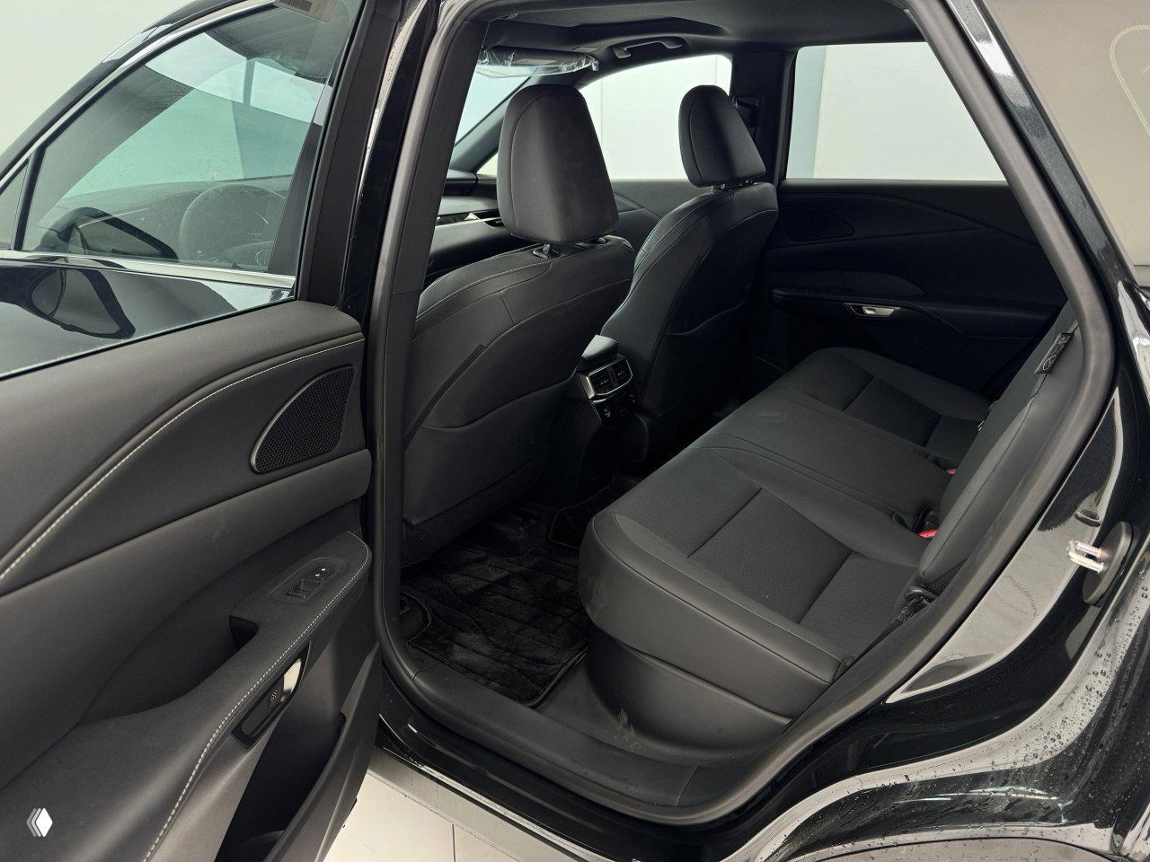 Вид на задний ряд сидений Lexus RX300 2025 в открытой двери — пространство для ног и состояние обивки с ракурса двери.