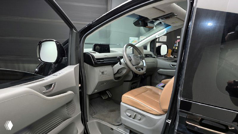 Открытая дверь водителя Hyundai Staria: вид на водительское место и переднюю панель, порог и элементы отделки двери в салоне минивэна.