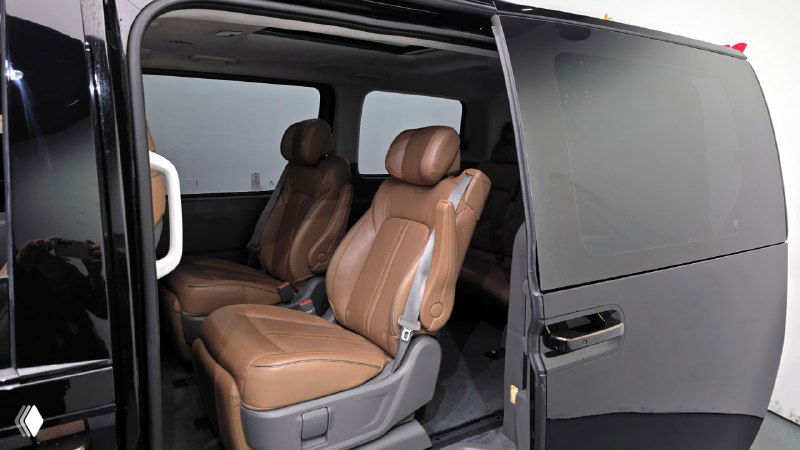 Раздвижная боковая дверь Hyundai Staria открыта — вид на средний ряд кресел и внутреннюю отделку салона, демонстрация доступа к пассажирскому отсеку.