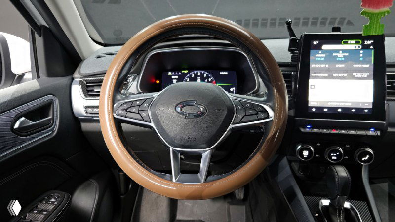 Крупный план руля и приборной панели Renault XM3 с подсветкой и цифровой комбинацией приборов, видна декоративная накладка на руле.