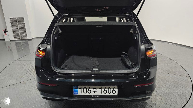 Открытый багажник чёрного Volkswagen Golf 2025 года, пустой багажник с видимыми упорами и полом пространства для груза.