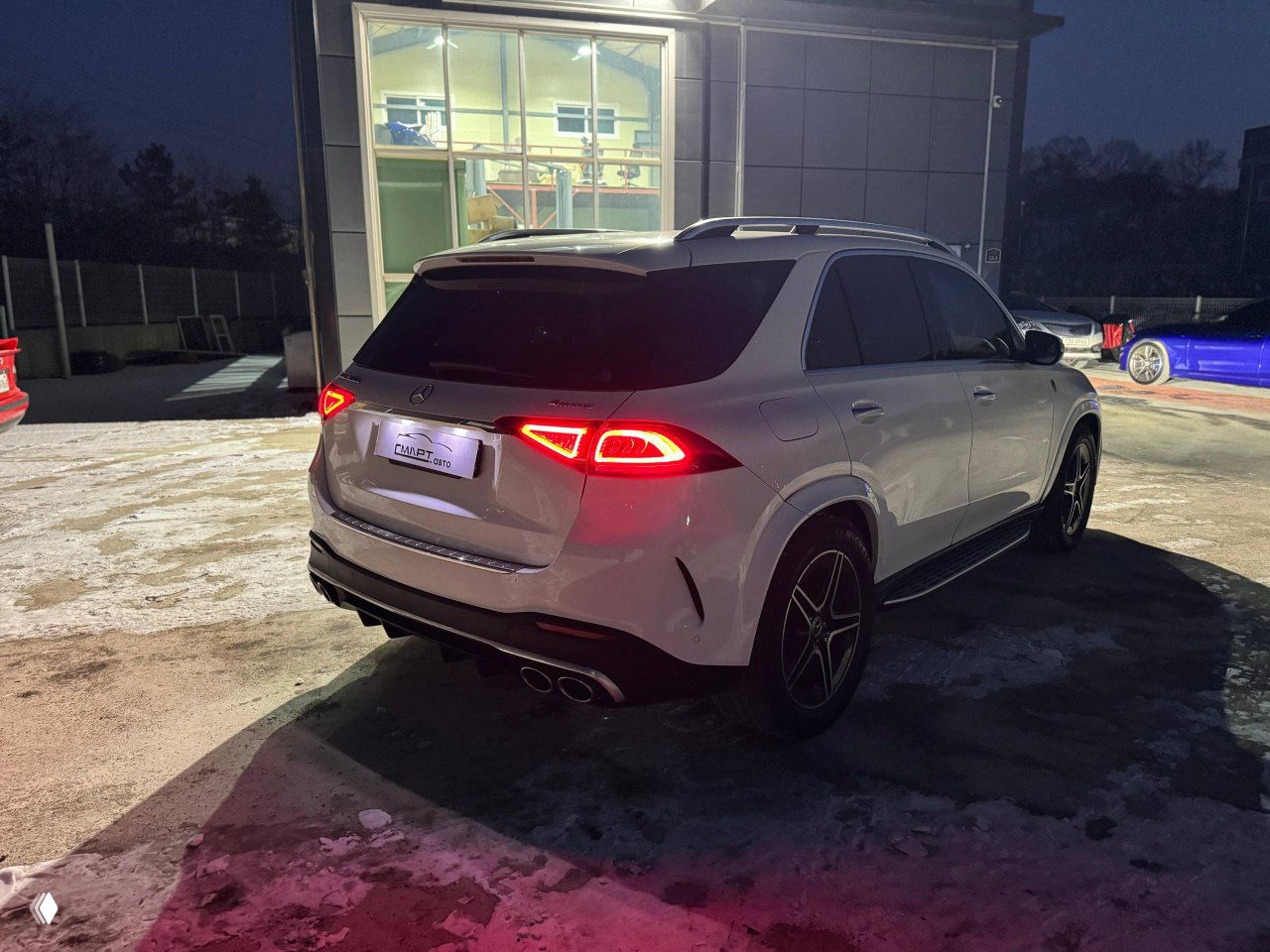 Ещё один вид сзади белого Mercedes GLE 300D 4Matic на стоянке, чётко видны линии задней части и световые элементы.