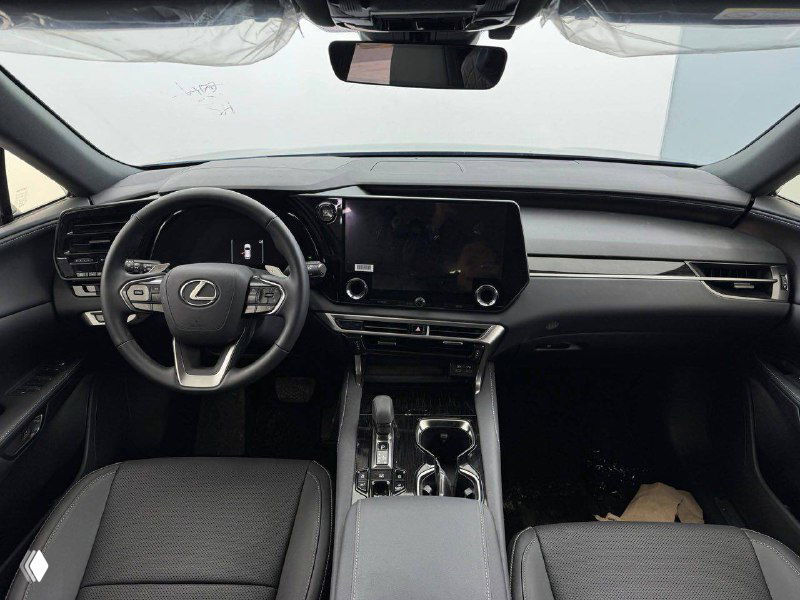Общий вид передней панели и центральной консоли Lexus RX 300 2025 — руль, мультимедиа экран и элементы управления в салоне автомобиля.