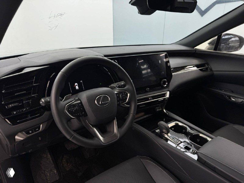 Ещё один ракурс передней панели и рулевого управления Lexus RX 300 2025 — демонстрация размещения экранов, рычага переключения передач и отделки салона.