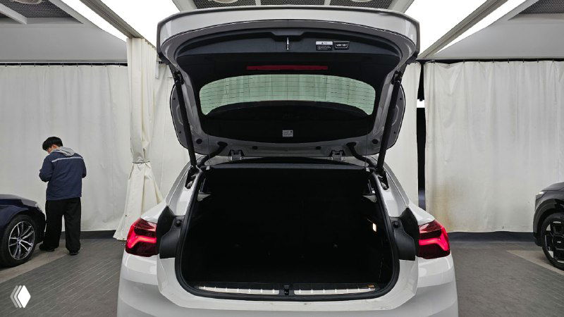 Открытый багажник BMW X2 с видом на грузовое пространство, пространство багажника пустое и подготовлено для демонстрации размера объёма.