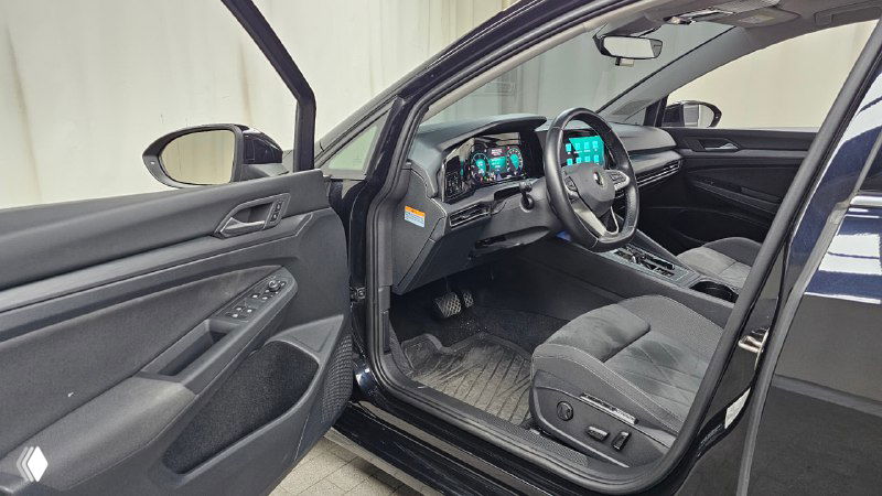 Открытая передняя дверь и водительский проём салона Volkswagen Golf 2022 — обзор обивки, посадочного места и дверной панели, состояние салона видно на фото.