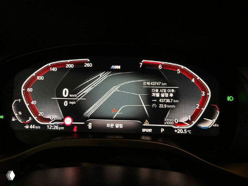 Цифровая приборная панель BMW X3 с отображением пробега, скорости и режимов вождения; тёмный интерьер и подсветка центра приборов.