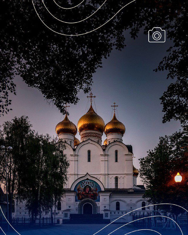 Успенский собор Ярославля в панорамном кадре: золотые купола и фасад среди деревьев на фоне сумеречного неба, туристический ракурс.