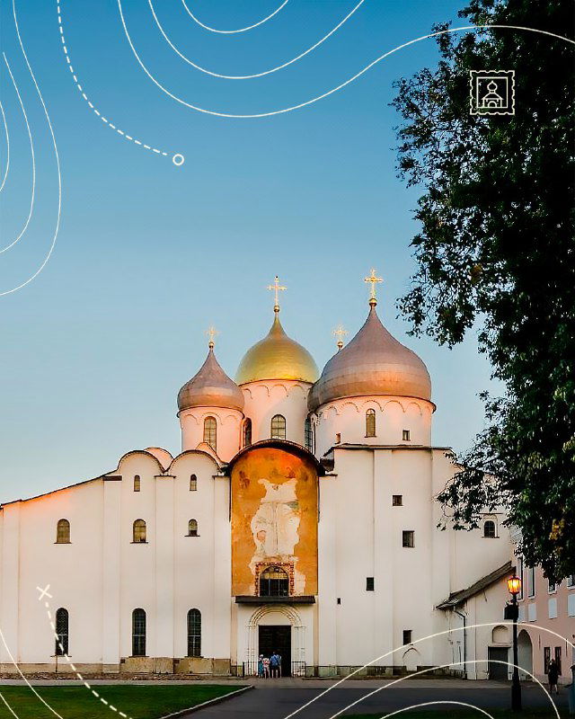 Фасад Софийского собора Великого Новгорода: белые стены, золочёные купола и фрески у входа на фоне мягкого дневного неба и зелёных деревьев.