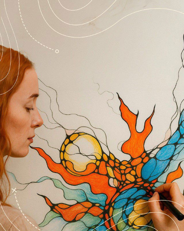 Женщина рисует на холсте абстрактный яркий рисунок: процесс арт‑терапии, аккуратные линии и цветовые пятна в мастерской или на пленэре.