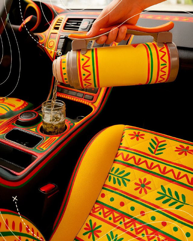 Деталь салона: термос и чехлы сидений, расписанные в филимоновском орнаменте — пример применения народной росписи в автомобиле.
