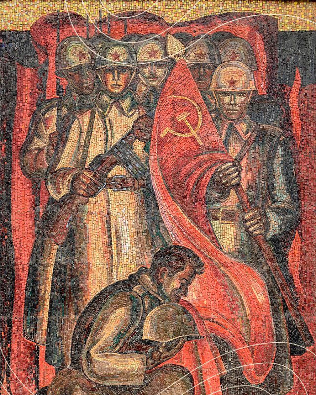 Деталь мозаики с изображением рабочих и красного знамени — сценография советской эпохи в яркой мозаичной технике на панели.