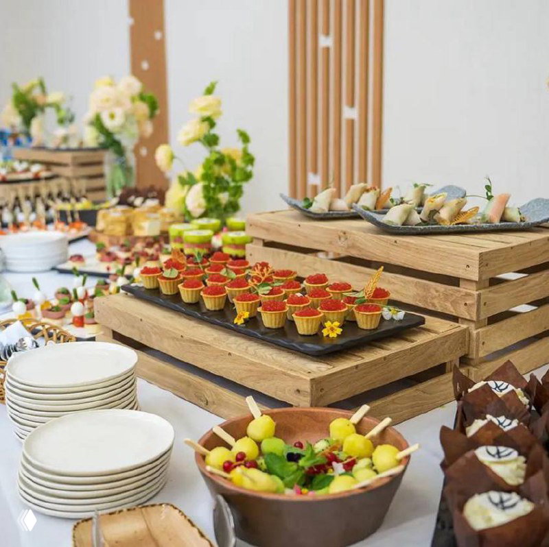 Богатый банкетный стол с канапе, фруктами и десертами — пример романтического ужина при свечах в рамках турпакета.