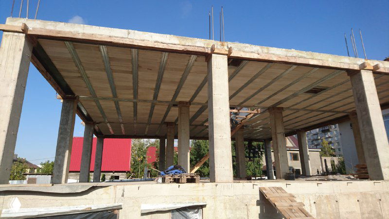 Вид снизу на установленное облегчённое перекрытие МАРКО: опалубка, поддерживающие стойки и простенки цокольного этажа в разрезе.