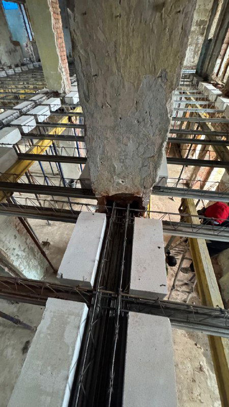 Ближний план сопряжения старой кирпичной колонны и новых профильных балок системы СМП МАРКО, видно соединение старой кладки и новых несущих элементов.