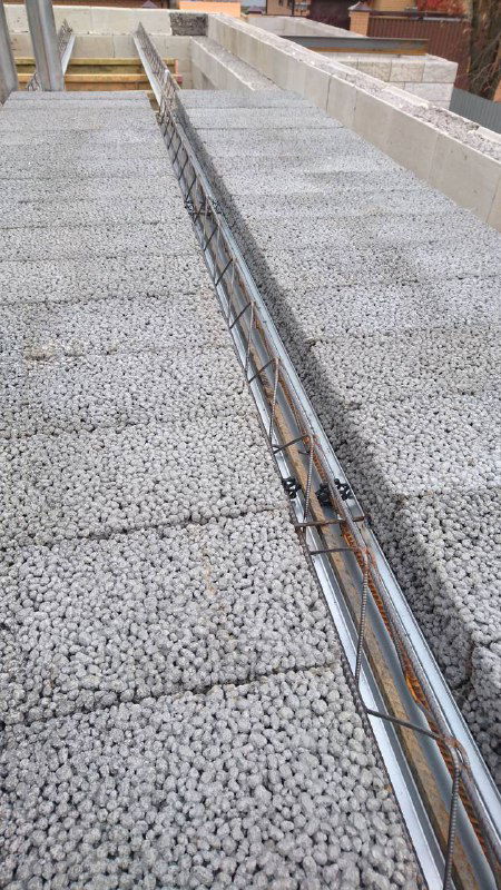 Укладка керамзитобетонных блоков с видимой арматурой в поясах перекрытия, подготовка к заливке монолитного пояса.