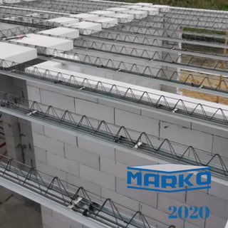 Фрагмент строительной площадки: промышленно изготовленные железобетонные/металлические элементы перекрытий и армирующие прогоны на фоне блоков газобетона с логотипом MARKO.
