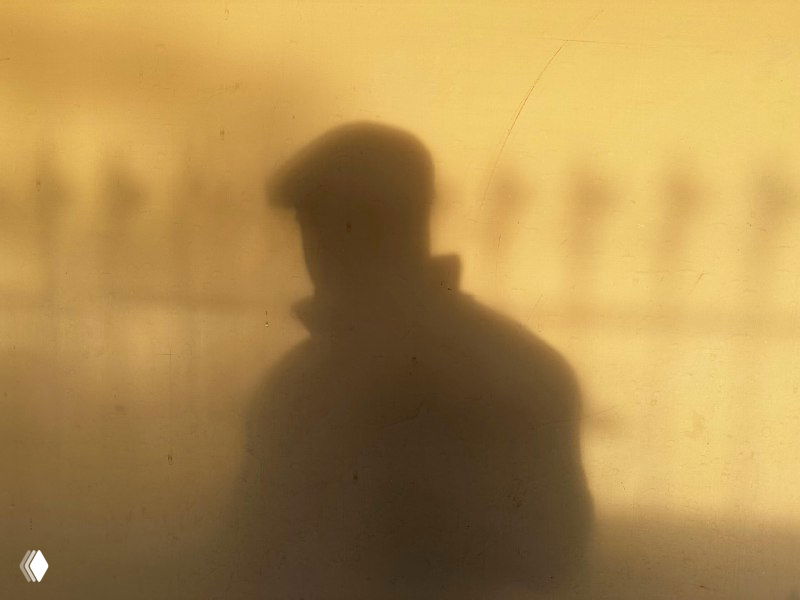 Тёплая тень силуэта человека на стене, образ невидимости и скрытой экспертности, визуальная метафора для темы поста