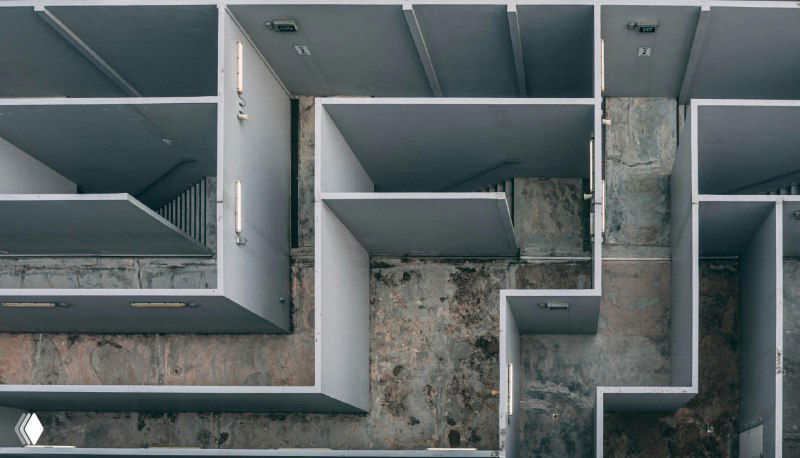 Вид сверху на лабиринт коридоров и стен — метафора сложных карьерных путей, барьеров и необходимости находить выход для роста.