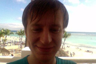 Селфи молодого мужчины на фоне пляжа и моря, солнечный дневной свет, кадр снят отчётливо в отпускной обстановке с морским пейзажем на заднем плане