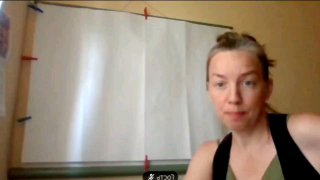 Кадр из видеозаписи эфира: женщина в комнате перед белым фоном смотрит в камеру, скрин с практики «Хочу на ручки Ресурсная Цветущая», кадр без узнаваемых подписей.