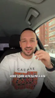 Автор канала в белом свитере сидит в машине на фоне жилого дома; вертикальное превью с надписью о новогодней неразберихе.