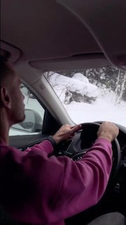 Водитель за рулём автомобиля на фоне глубоко заснеженной обочины и деревьев — кадр из спонтанного автопутешествия в сторону Шерегеша и Алтая.