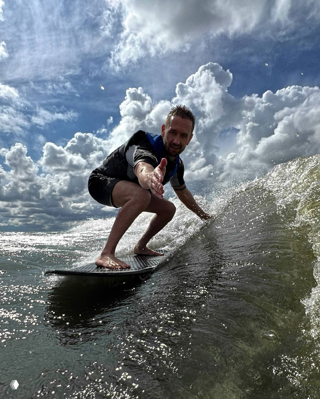Человек на доске в момент серфинга, вода и брызги вокруг; спортивный кадр подчёркивает увлечение и активный образ жизни автора.