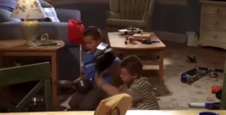 Дети играют в гостиной: игрушки и хаос на полу — кадр из сериала, показывающий материнские трудности Линетт и семейное напряжение.