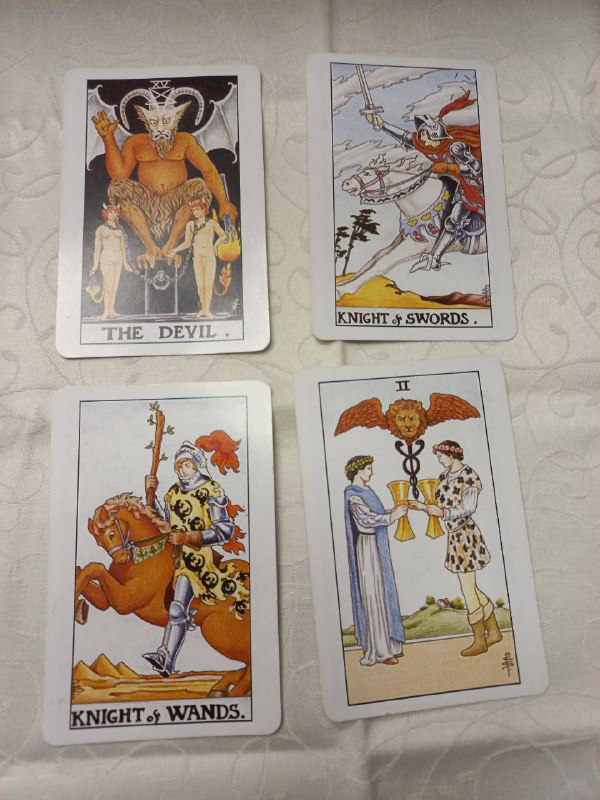 Фото второго расклада Таро классической колоды: карты Дьявол, Рыцарь Мечей, Рыцарь Жезлов и Двойка Кубков разложены на светлой ткани.