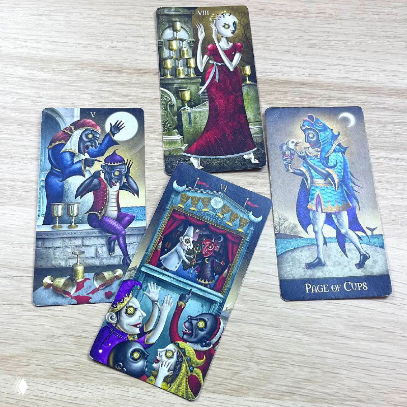 Фотография нескольких карт Таро на столе: арканы с яркими персонажами в театральных позах и насыщенными цветами