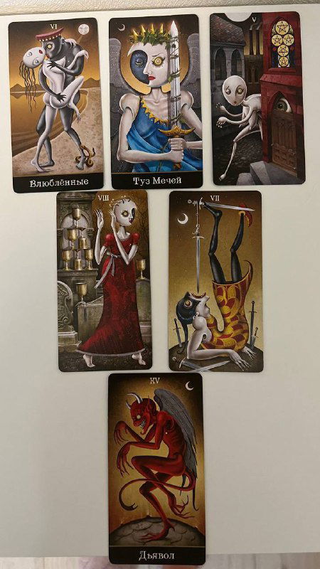 Крупный план расклада таро в вертикальном кадре: карты расположены в две строки, центральная карта — Дьявол; художественный стиль колоды заметен на изображении.