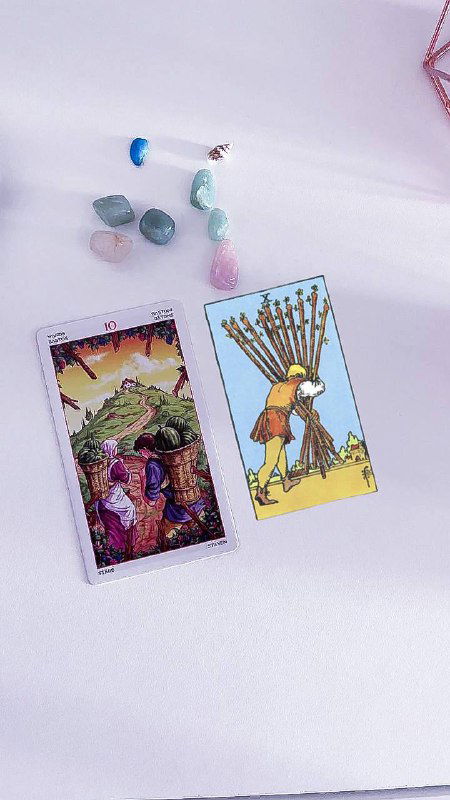 Крупный план карт Таро: сцены 9 и 10 Жезлов на белом фоне, виден измученный персонаж с грузом и агрессивная атмосфера, рядом кристаллы и аксессуары раскладки.