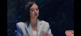 Кадр из видео: женщина в светлом пиджаке жестами объясняет на тёмном фоне; крупный план ведущей, к посту о Таро и колоде.