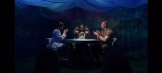 Три человека за столом с колодой Таро в полутёмной комнате: таролог показывает расклад, ощущение церемонии и обсуждение карт