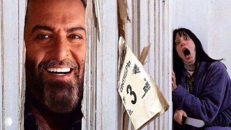 Кадр в кинематографическом стиле: мужчина выглядывает через расколотую дверь, рядом напуганная женщина — мем‑изображение.