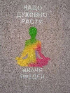 Трафаретная надпись на полу «Надо духовно расти, иначе пиздец» с силуэтом в позе медитации радужных цветов — провокационный юмор.